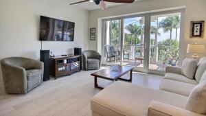 a living room with a couch and chairs and a television at 406 Mariners Club in Key Largo