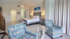 a hotel room with a bed and a couch and chairs at 406 Mariners Club in Key Largo +38 photos