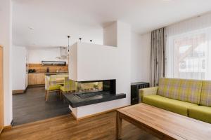 a living room with a couch and a fireplace at Alpinium - inklusive SUPER SOMMER CARD in Fiss