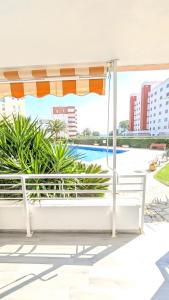 a patio with an umbrella and a pool at Apartamento Mar y Encanto in Miami Platja