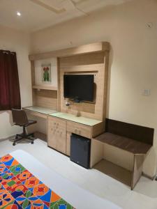 a room with a desk with a television and a chair at Hotel Santoor - Geeta Bhawan Square in Indore