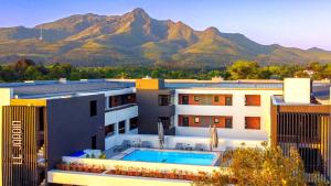 a building with a swimming pool in front of mountains at Luxury Apartment Unit 101 in George