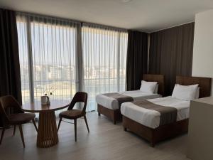 a hotel room with two beds and a table at Alya Rooms in Lefkosa Turk