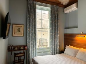 a bedroom with a bed and a window at The Norfolk, Paddington in London