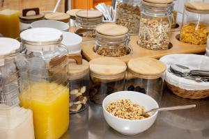 a counter with jars of food and a bowl of granola at Hotel Gästehaus Lutgen in Waldfeucht +8 photos