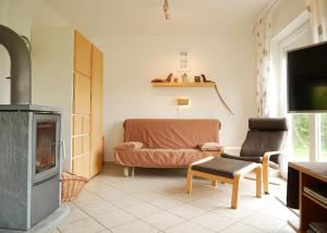 a living room with a couch and a tv at Villa Pepita in Kaltenhof