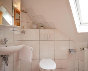 a white bathroom with a toilet and a sink at Villa Pepita in Kaltenhof +23 photos