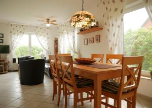 a dining room with a wooden table and chairs at Villa Pepita in Kaltenhof