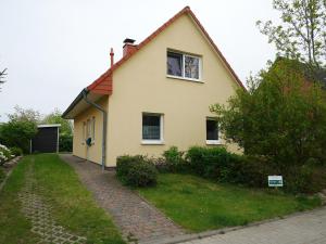 a yellow house with a window and a driveway at Villa Pepita in Kaltenhof