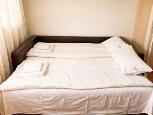 a bed with white sheets and towels on it at Udoban porodični apartman ViS Raška, 80m2, parking, bašta in Raška