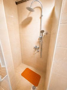 a bathroom with a shower with a orange mat in it at Udoban porodični apartman ViS Raška, 80m2, parking, bašta in Raška