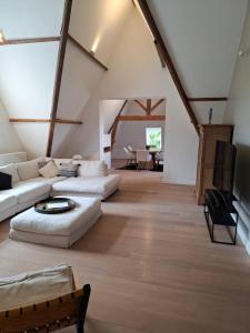 a living room with white couches and a tv at Un Toit sur les Monts in Tilff