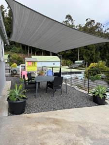 a patio with a table and chairs under a canopy at Lebon Coin Tranquille in Le Tampon