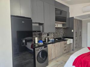 a kitchen with a washing machine in a room at De Oude Sleeper Inn 2 Apartment in Kimberley