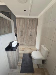 a bathroom with a toilet and a sink at De Oude Sleeper Inn 2 Apartment in Kimberley