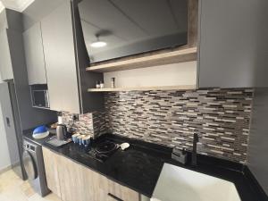 a kitchen with a black counter top and a brick wall at De Oude Sleeper Inn 2 Apartment in Kimberley