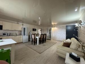 a kitchen and living room with a couch and a table at Hotel DALIM in Duliby
