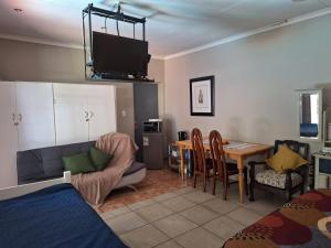 a living room with a couch and a table with a tv at SMAPERS GUESTHOUSE in Brits