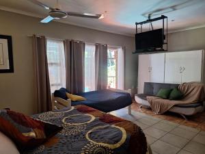 a living room with a bed and a couch at SMAPERS GUESTHOUSE in Brits +30 photos