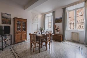 a dining room with a table and chairs and a television at Residenza d'Epoca " Il Campo" by FrancigenaApartments in Siena