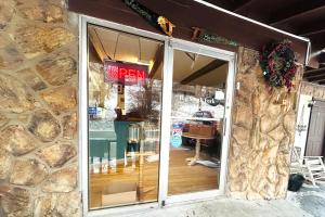 a stone building with a glass door of a restaurant at Big South Fork Trail Lodge Stearns in Stearns