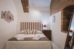 a bedroom with a bed with towels on it at Residenza d'Epoca " Il Campo" by FrancigenaApartments in Siena
