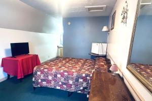 a bedroom with a bed and a table and a mirror at Big South Fork Trail Lodge Stearns in Stearns