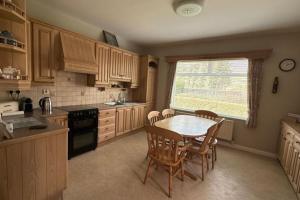 a kitchen with a table and chairs and a window at Greenway Riverside House - Cahersiveen in Foilmore Bridge
