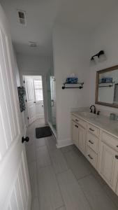 a bathroom with a sink and a shower and a mirror at Sandnapper in Pawleys Island +23 photos
