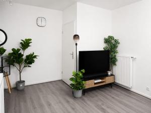a living room with a flat screen tv and plants at Noisiel appartement 2piece in Noisiel