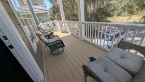 a balcony with chairs and a couch on a porch at Sandnapper in Pawleys Island