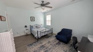 a bedroom with a bed and a blue chair at Sandnapper in Pawleys Island