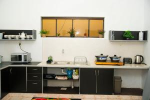 a kitchen with a counter with a sink and a microwave at GuestHouse Encanto del Centro in Encarnación +15 photos