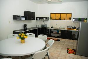 a kitchen with a white table and a table and chairs at GuestHouse Encanto del Centro in Encarnación