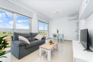 a living room with a couch and a table at Aparthotel Laguna Rosa in Los Montesinos