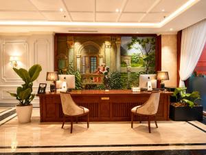 a reception desk with two chairs and a mirror at Happy Life Grand Hotel & Rooftop Skybar in Ho Chi Minh City
