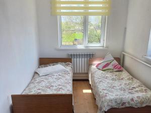 two beds in a small room with a window at Beksultan guest house in Epkin