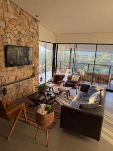 a living room with a couch and a stone wall at Casa Capim Limão in Cavalcante