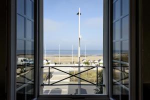 an open window with a view of a beach at Les quatre vents in Luc-sur-Mer +13 photos