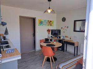 a living room with a table and a desk at Ty Colibri Lannion in Lannion