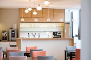 a restaurant with tables and chairs and a counter at Kloster Heidberg in Eupen