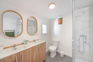 a bathroom with a sink and a toilet and two mirrors at Apartamento Casa Sol Ronda in Ronda +13 photos