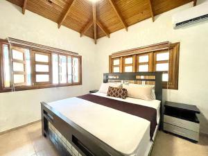 a bedroom with a large bed in a room with windows at villa regazo de paz in Concepción de La Vega +62 photos