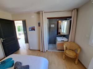 a room with a bed and a bathroom with a mirror at Chambre d'Hôtes Valérie in Penvénan +1 photo