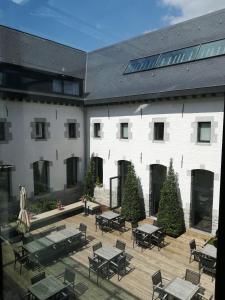 a courtyard with tables and chairs in front of a building at Kloster Heidberg in Eupen