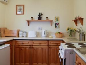 a kitchen with wooden cabinets and a counter top at Crail House in Crail