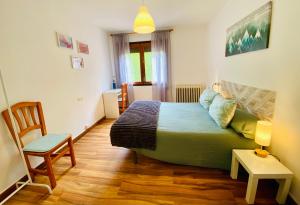 a small bedroom with a bed and a chair at Benvinguts a Casa Nostra in El Pont de Suert