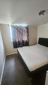 a bedroom with a bed with a painting of zebras at Leilighet med 2 soverom in Storen