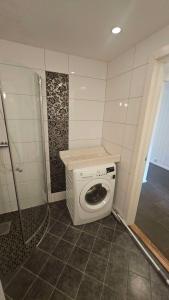 a washing machine in a bathroom with a shower at Leilighet med 2 soverom in Storen