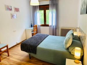 a bedroom with a bed and a desk and a table with two lamps at Benvinguts a Casa Nostra in El Pont de Suert +5 photos